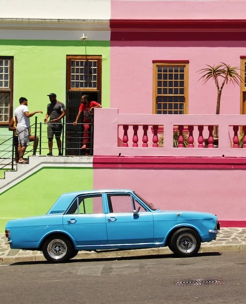 A vibrant street scene in Little Havana, Miami, with colorful buildings, classic cars, and people engaging in various activities like domino games and enjoying Cuban coffee.