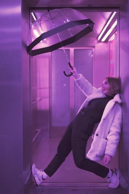 A GTA 6 character using a grappling hook device to discreetly access a rooftop, bypassing a crowded street below. The image emphasizes the use of alternative, non-violent methods for infiltration and mission completion, highlighting the game's diverse strategic options.