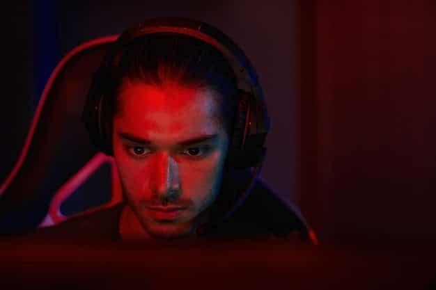 A close-up shot of a gamer's intense face, lit by the glow of a monitor displaying a graphically demanding game, highlighting focus and immersion.